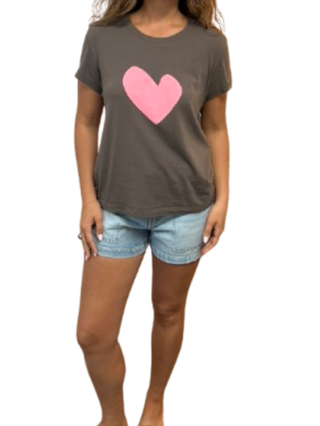 Person wearing a brown t-shirt with a pink heart design and denim shorts on a white background