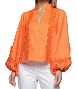 Orange blouse with intricate detailing on a white background