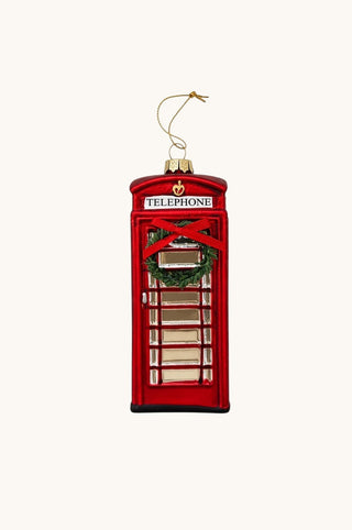 A red telephone booth Christmas ornament with a gold hanging string, featuring a green wreath detail and the word 'TELEPHONE' on a white sign.