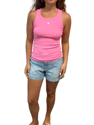Person wearing a pink tank top and denim shorts on a white background