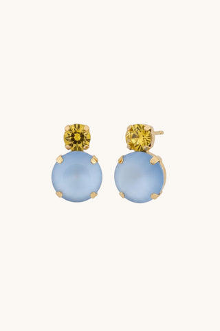 A pair of gold drop earrings featuring a round light blue cabochon stone and a smaller round yellow gemstone at the top, set against a plain off-white background.