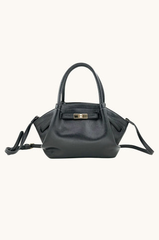 A black leather handbag with a structured shape, double top handles, a front gold-tone turn-lock clasp, and a detachable shoulder strap, shown against a plain off-white background.