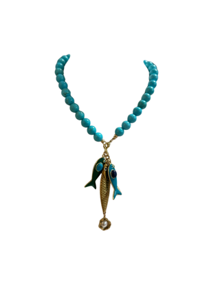 Turquoise beaded necklace with a fish pendant on a white background